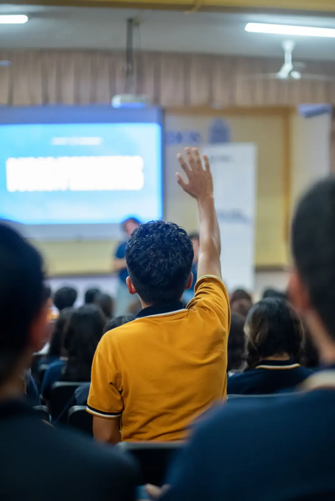 Audience member raising a hand during a seminar session