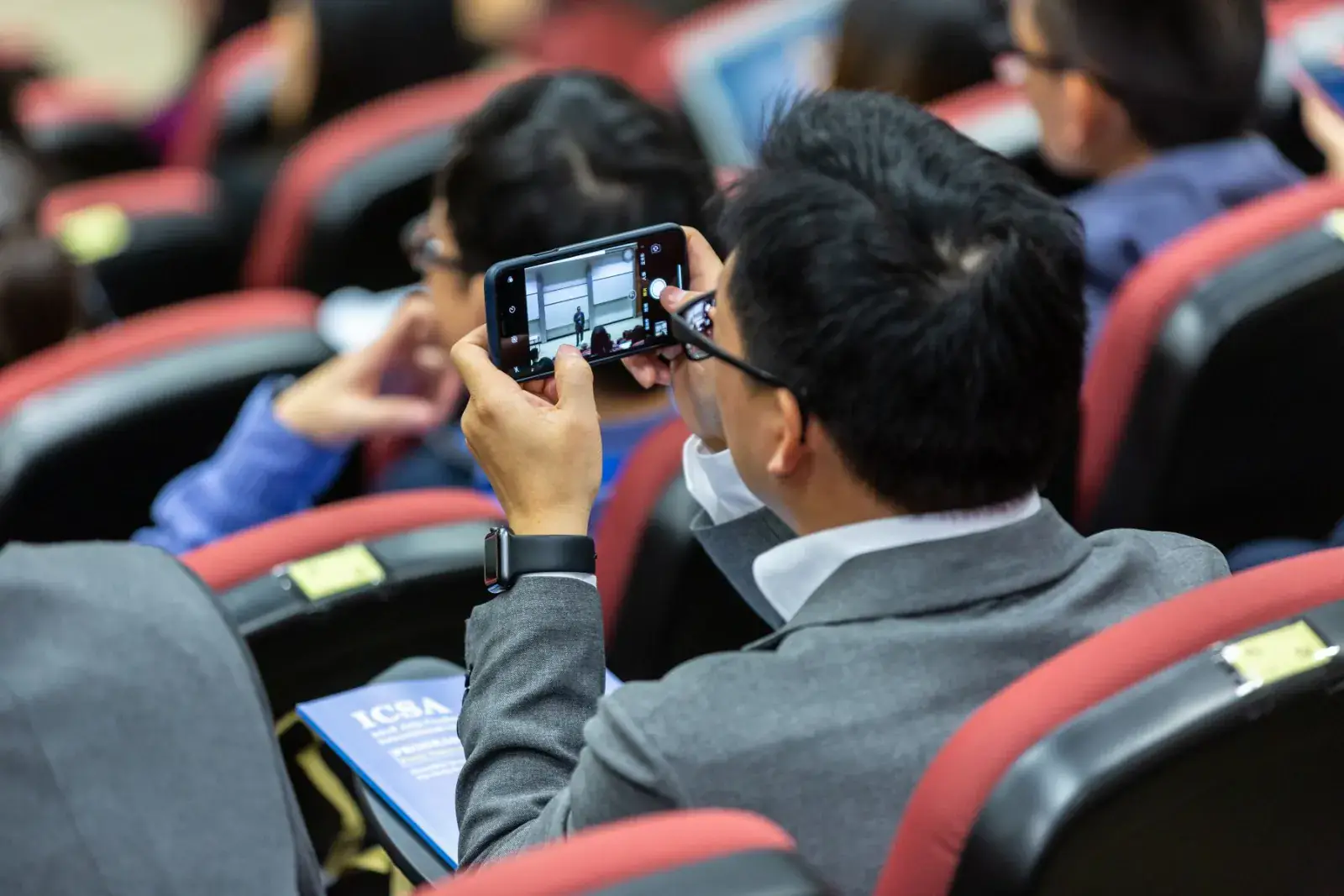 Delegates seated in an auditorium during a conference session