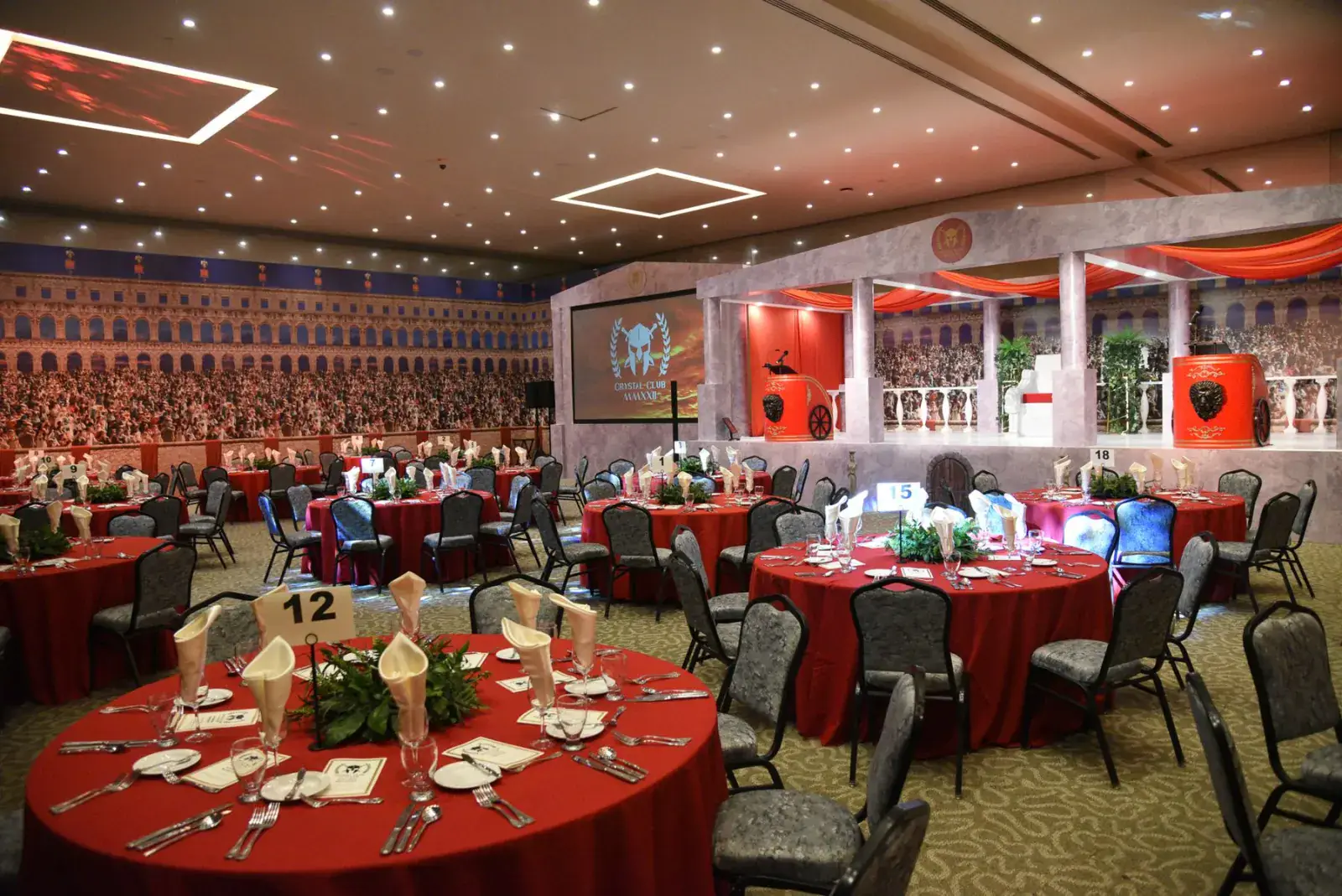 Banquet hall set with red round tables ahead of a corporate evening