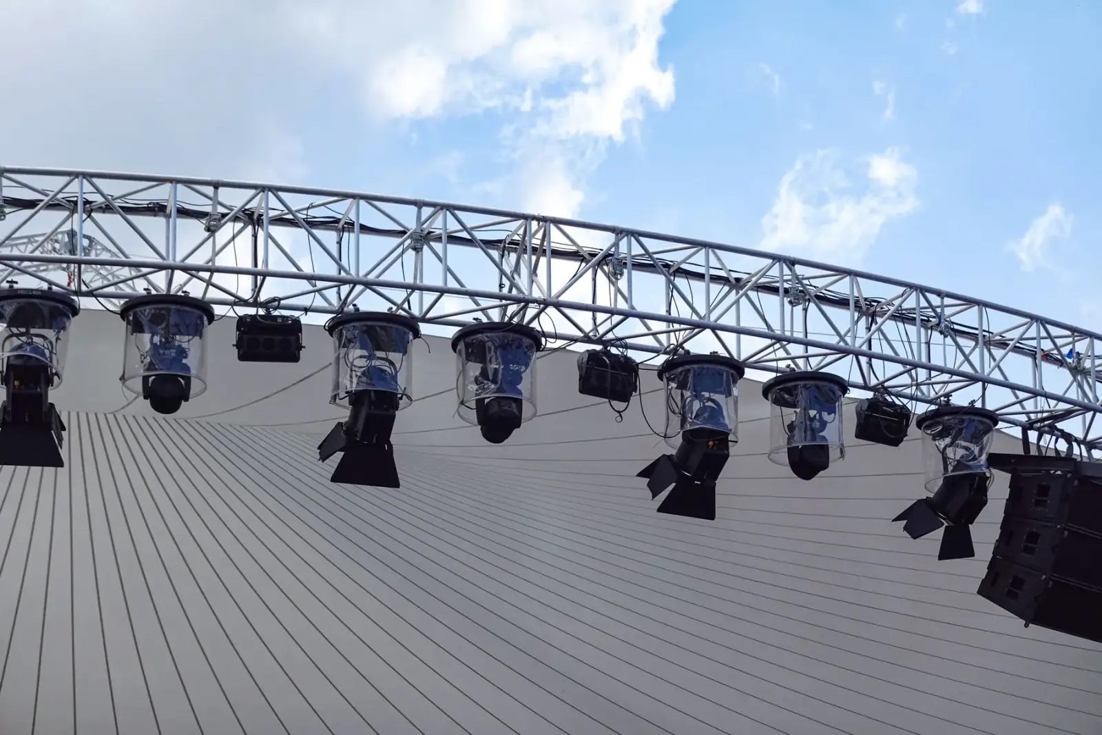 Overhead lighting truss loaded with moving-head fixtures above a stage
