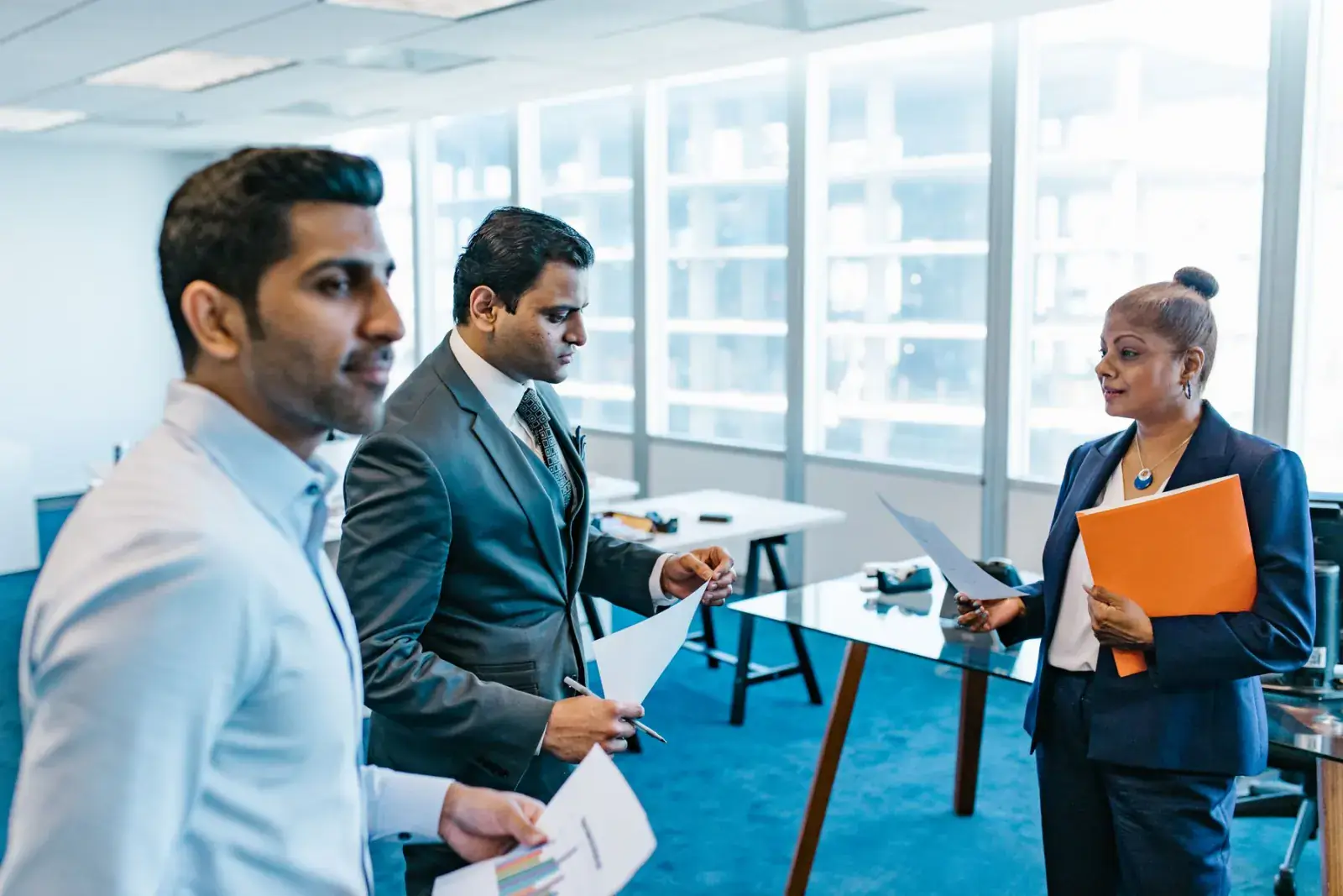 Business colleagues in conversation with documents during an event break