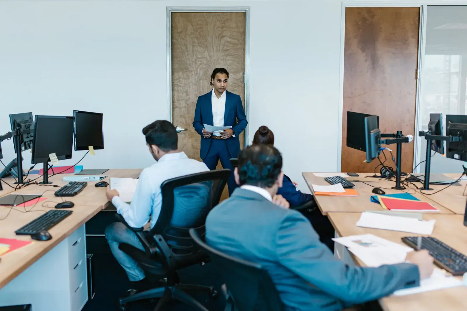 Team seated around a workstation while a colleague presents
