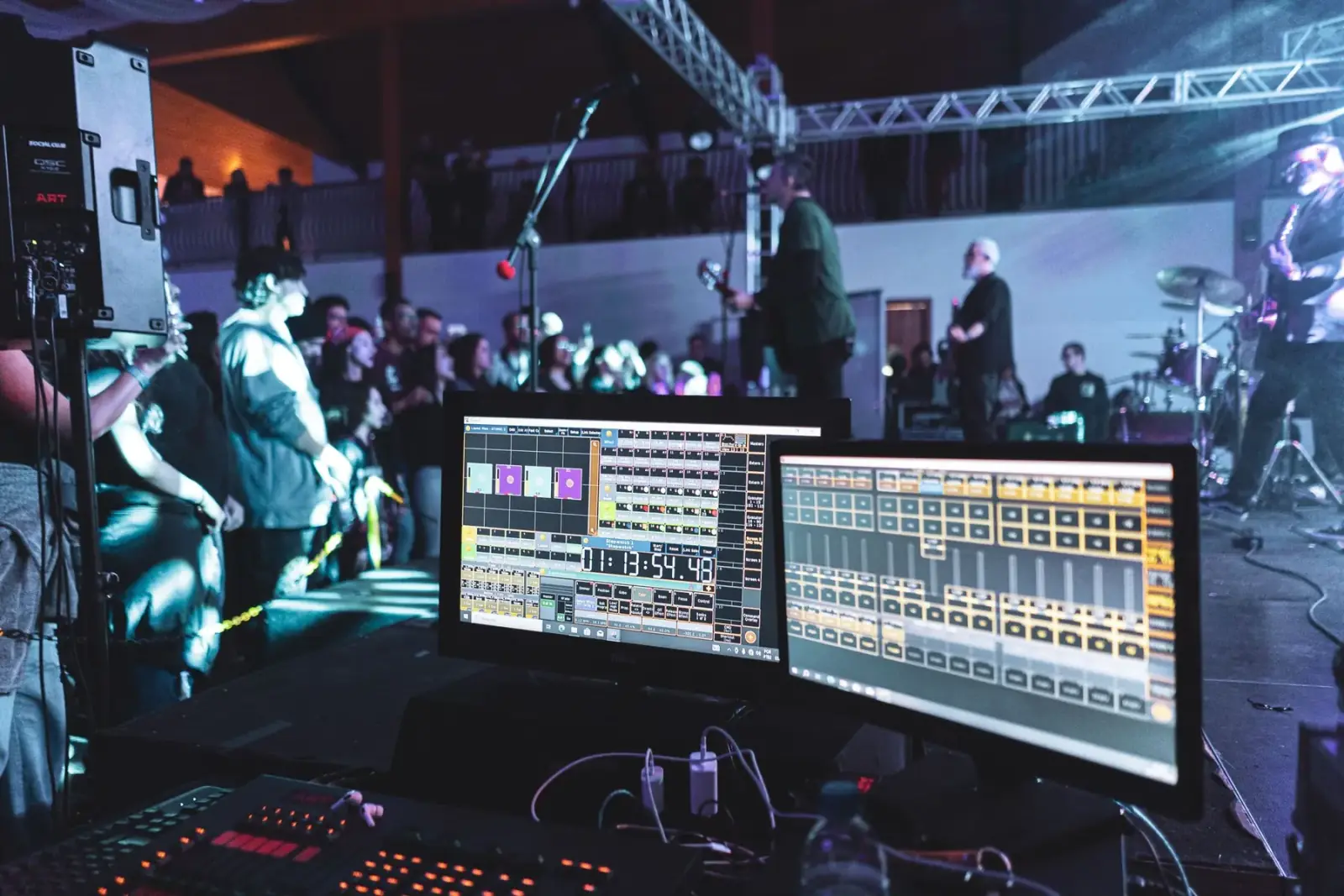 Lighting and show control desk operating in front of a lit stage