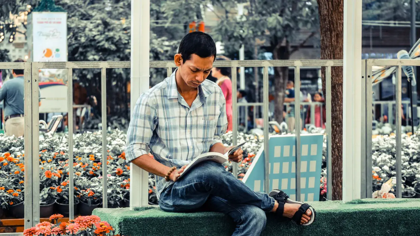 Reader with an open magazine on a city bench