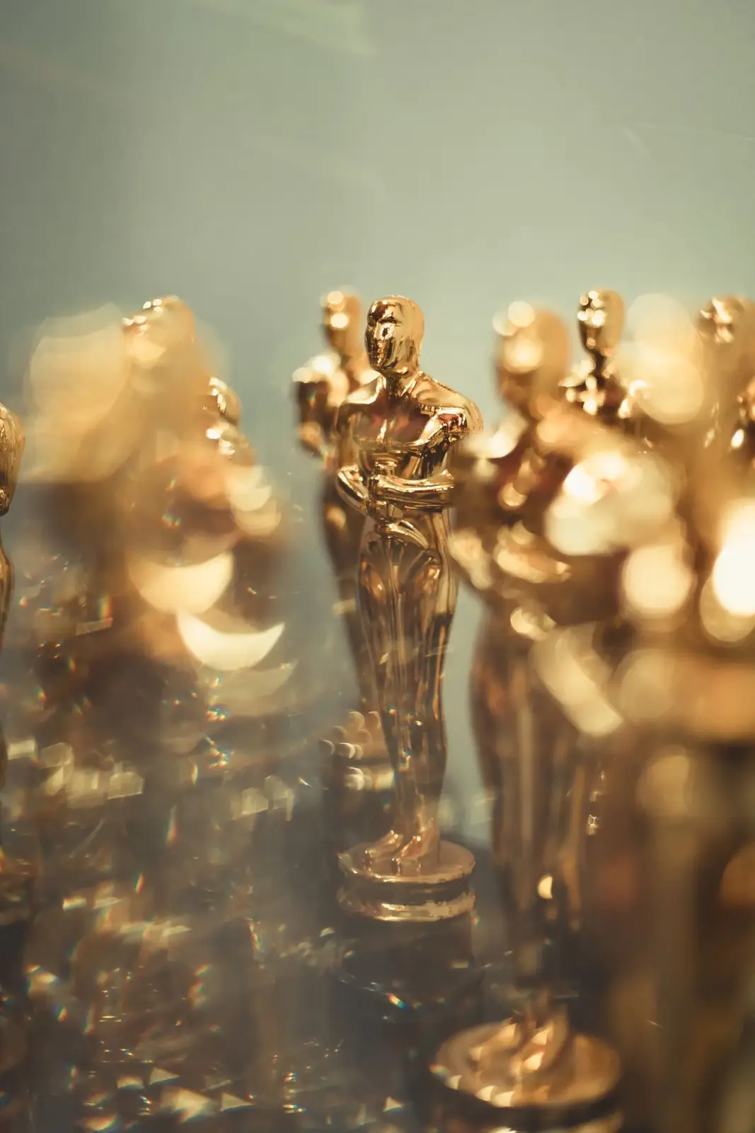 Row of gold award statuettes in warm shallow-focus light