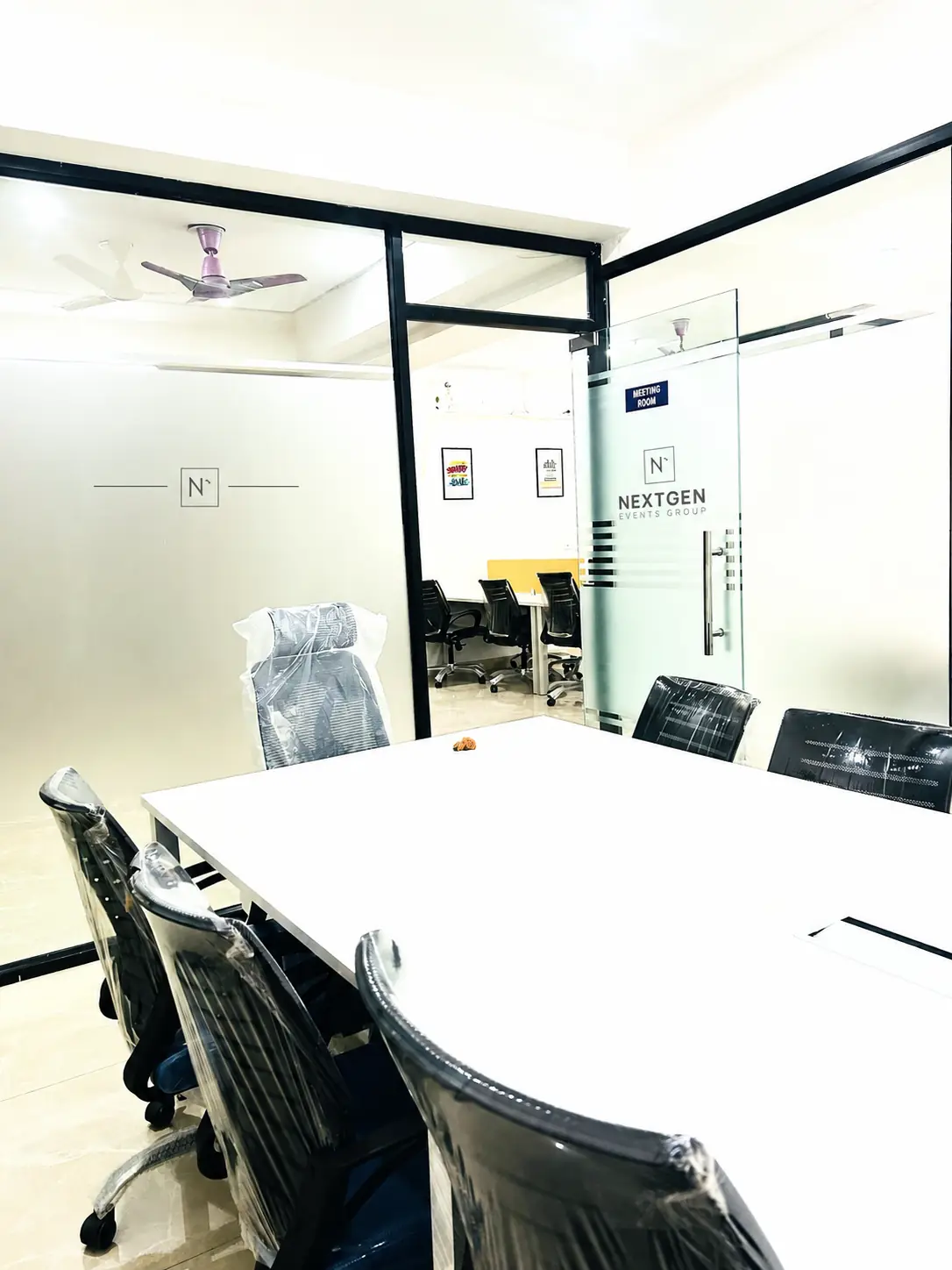 NextGen Events Group meeting room with a large white conference table and branded glass door