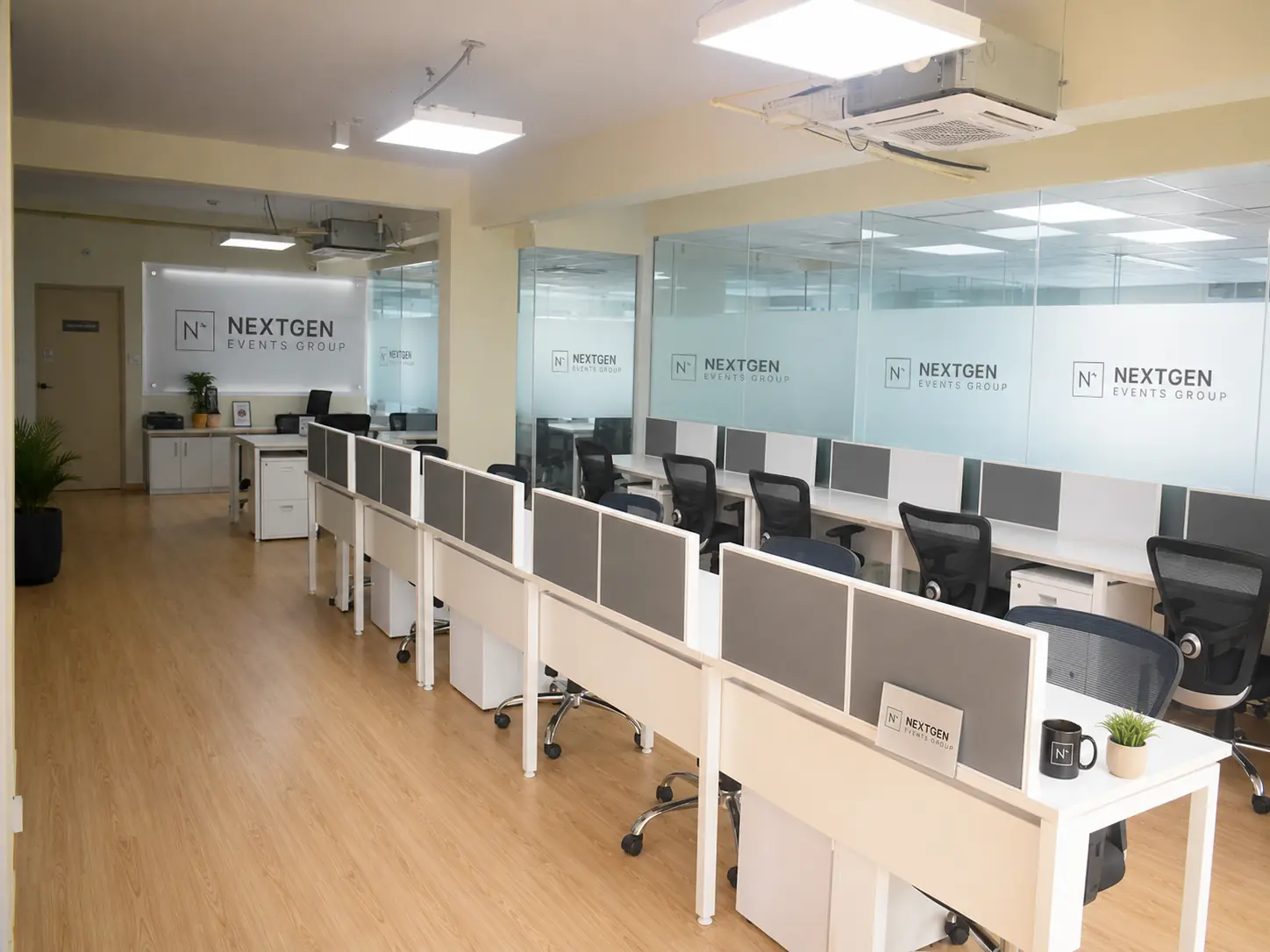 Open-plan NextGen Events Group workspace in Bengaluru with branded glass partitions and workstations